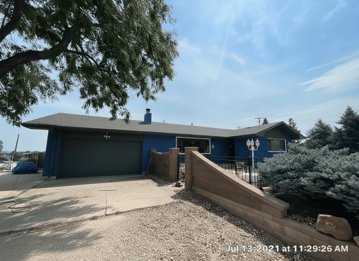 Home exterior with blue siding, gray garage door, and landscaped yard, showcasing a property potentially restored after hail damage, relevant to Sorensen Roofing & Restoration services.